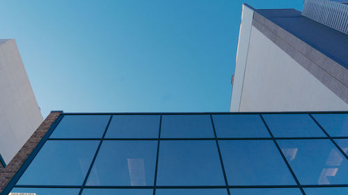 Low angle view of office building against blue sky