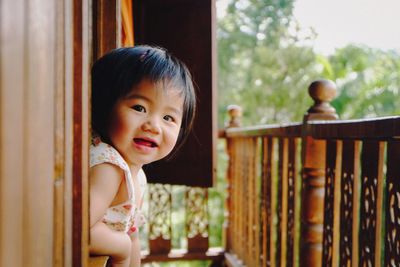 Portrait of cute baby girl leaning on window sill