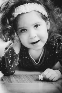 Portrait of smiling girl lying on floorboard