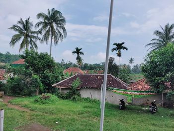 Built structure by trees and plants against sky