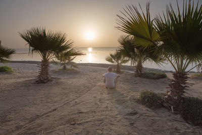 Rear view of man looking at sea against sky