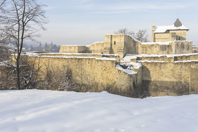 Snow covered buildings against sky