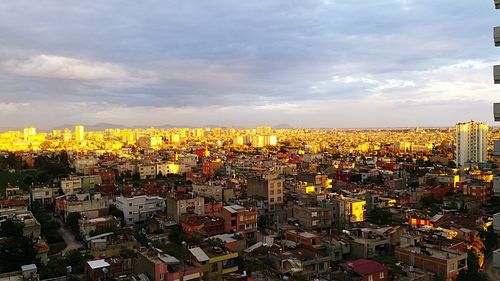 View of cityscape against cloudy sky