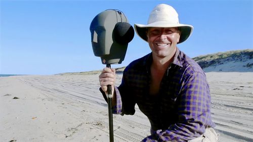 Filmmaker christopher seufert with microphone at cape cod national seashore. 