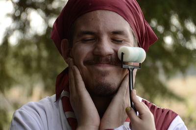 Close-up portrait of young man drinking outdoors