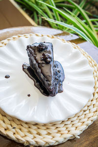 Chocolate cake slice with generous chocolate sauce, a cut piece on a table of a cafe restaurant.