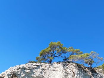 Low angle view of rock formation against clear blue sky