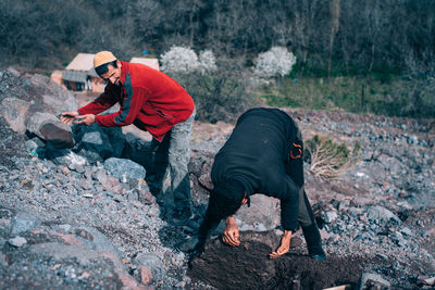 People on rock by road during winter