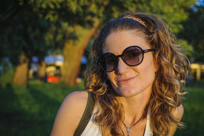 Portrait of young woman wearing sunglasses while standing outdoors