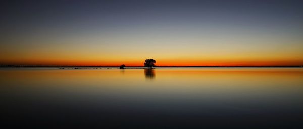 Scenic view of sea against orange sky