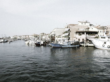 Boats moored in sea against clear sky