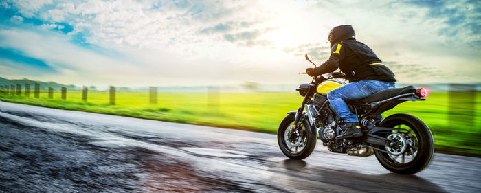 Motorcycle on road against cloudy sky