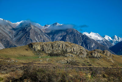 Scenic view of snowcapped mountains against blue sky