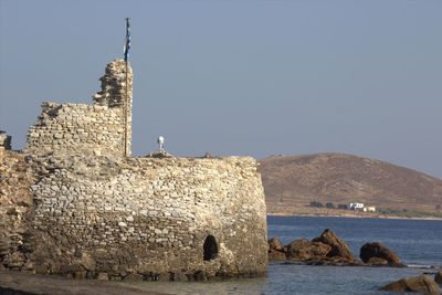 Built structure by sea against clear sky