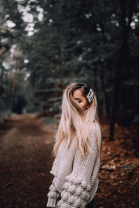 Woman standing by tree in forest