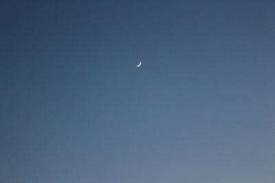 Low angle view of moon against clear sky at night