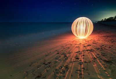 Burning steel wool firework on beach at night