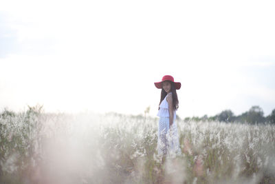 Full length of woman standing on field against sky