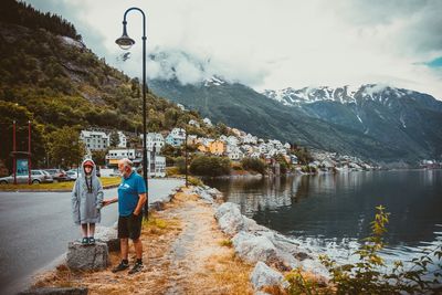 Men standing by lake against mountains