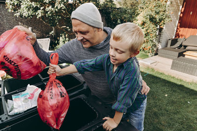 Father and son recycling waste in garden