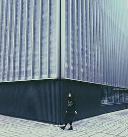 Full length of man walking by wall in city