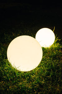 Close-up of illuminated light bulb on field