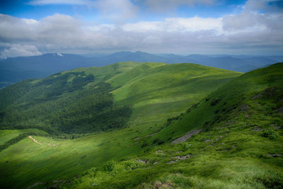 Scenic view of green landscape against sky