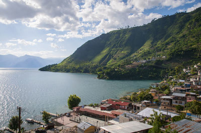 High angle view of town by sea against sky