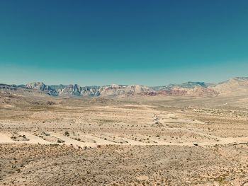 Scenic view of desert against clear blue sky