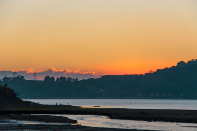 Scenic view of sea against orange sky