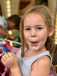 Little girl at the fancy fair enjoying a lollipop