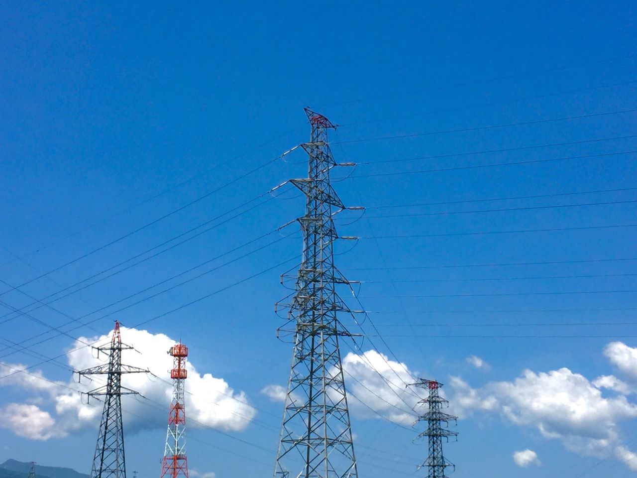 low angle view, power line, electricity, electricity pylon, power supply, fuel and power generation, connection, technology, cable, blue, sky, power cable, lighting equipment, silhouette, outdoors, communication, no people, pole, cloud - sky, built structure