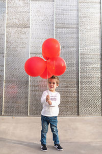 Full length portrait of boy standing on balloon