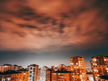 Illuminated buildings in city at sunset