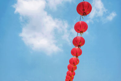 Low angle view of red lanterns hanging against sky