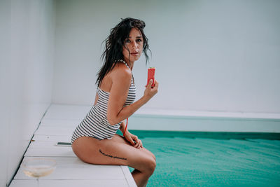 Woman sitting in swimming pool