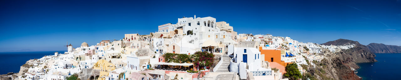 Panoramic view of buildings against blue sky