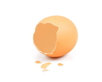 Close-up of broken egg against white background