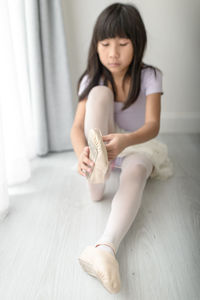 Low section of girl sitting on floor