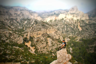 Man standing on cliff against mountain