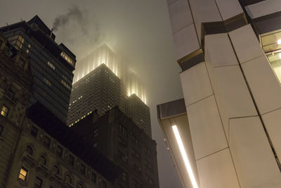 Low angle view of illuminated buildings against sky at night