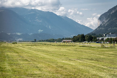 Scenic view of field and mountains against sky