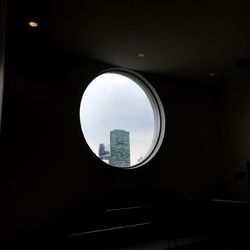 Directly below shot of buildings against sky seen through window