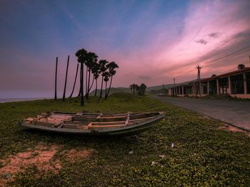 Boats moored on shore against sky during sunset