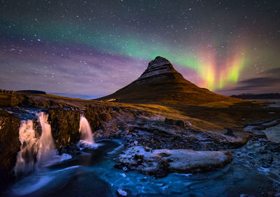 Scenic view of waterfall against sky at night