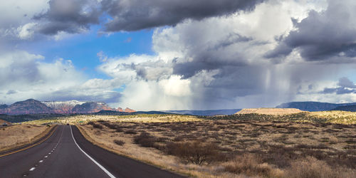 Panoramic view of country road against cloudy sky