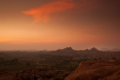 Scenic view of landscape and mountains against sky during sunset at hampi