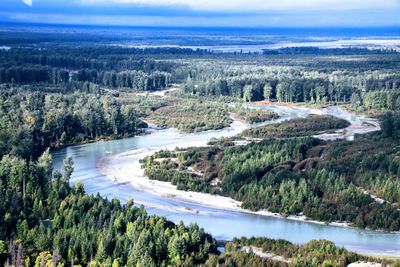 High angle view of river amidst trees against sky