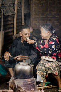 Side view of senior man sitting on table