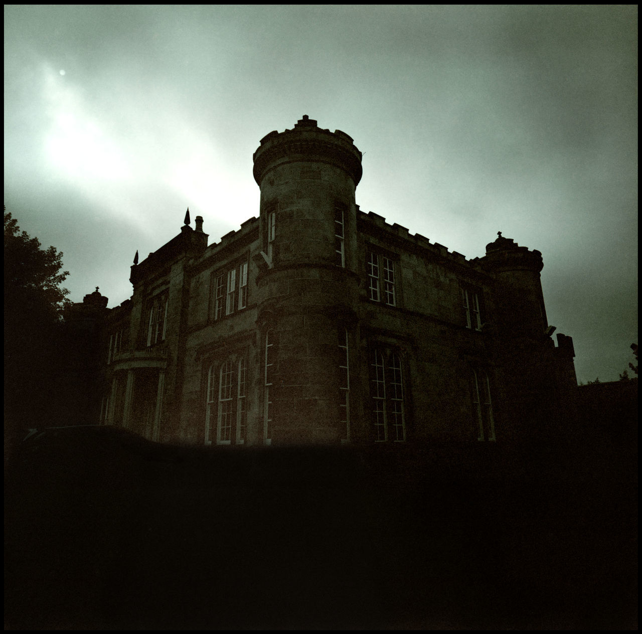 LOW ANGLE VIEW OF OLD BUILDING AGAINST SKY AT DUSK